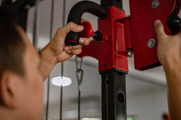 Training gym concept a muscled male teenager using a gym equipment repeating pushing forward for developing his muscle