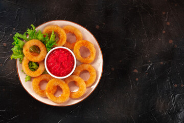 Calamari rings. Deep fried squid rings with green salad and tomato sauce, top shot with a place for text