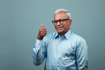 Happy Indian elderly man shows thumbs up sign