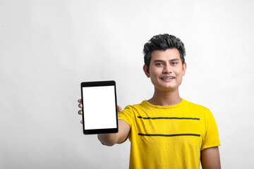 young indian man showing tablet over white background.