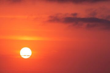 Orange sunlit sky with clouds