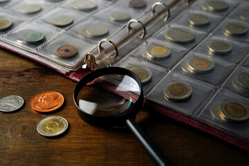Old collectible coins on a wooden table. Dark background. Banner. Numismatics, Coins in the album. Selective focus.  
