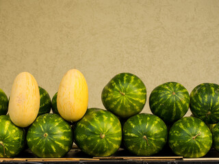 A counter with melons and watermelons. Sale of fruits, vegetables and berries, copy space