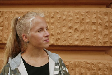 portrait of young woman against background of stone wall