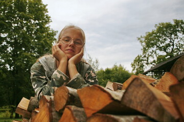 girl prepares firewood for the winter season