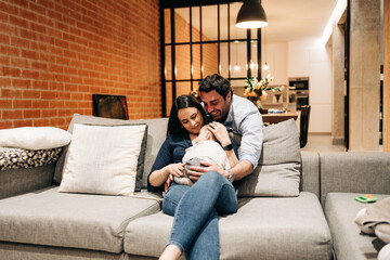 happy young family at home cuddling while baby is taking a nap