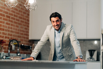portrait of smiling male in casual clothes sitting at the table at home office