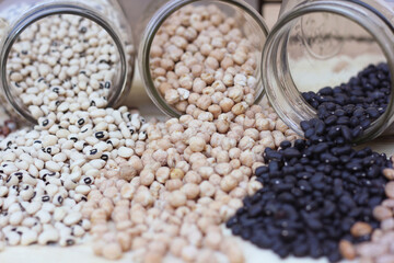 Obraz premium Jars of Black-eyed Peas, Chick Peas, Black Beans and Pinto Beans Spilled in Kitchen