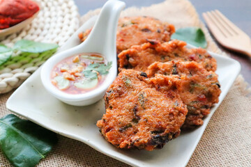Thai fish ball cake , in Thai called Tod Mun Pla Krai served with sweet chili sauce at top up view