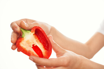 cut in half red pepper in hands on a light background vegetables