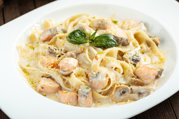Closeup on fettuccine pasta with salmon in cream sauce