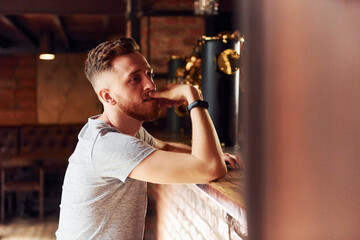 Man in casual clothes sitting in the pub at daytime