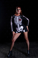 Woman with vampire bodypainting on the background of neon lights, carnival and party on day of the dead, halloween holiday.
