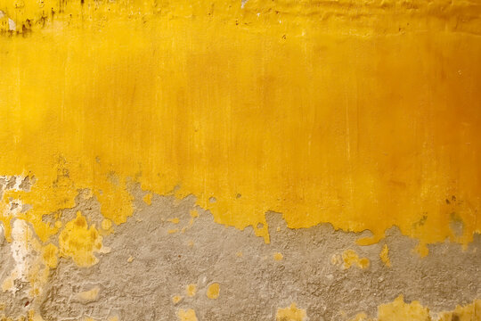 Gold yellow concrete blank wall with peeling paint for colorful vintage background