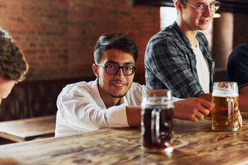 Alcoholic drinks. People in casual clothes sitting in the pub