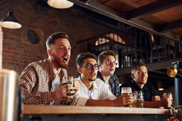 Celebrating victory. People in casual clothes sitting in the pub