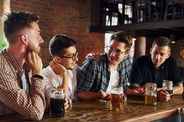 Positive friends. People in casual clothes sitting in the pub