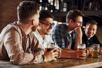 Positive friends. People in casual clothes sitting in the pub