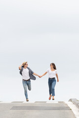 Happy couple running on the horizon of the road. Happiness concept with minimalist composition and copy space.