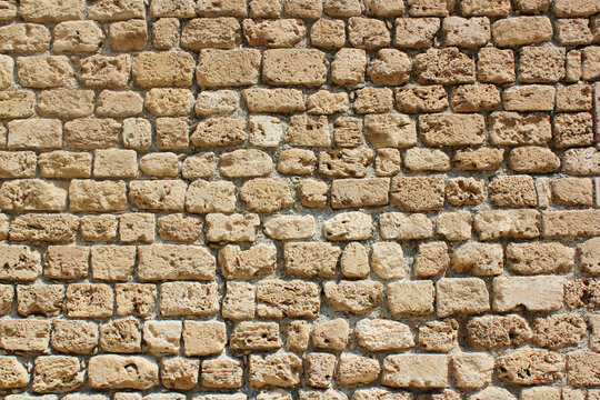 Alte Wand aus hellem, gelbem Sandstein in zypern. Hintergrundbild, Textur.