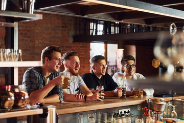 People in casual clothes sitting in the pub and drinking beer