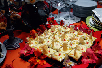 An elegant jelly and mousse snack decorated with flowers. Panna cotta in little square bowls....
