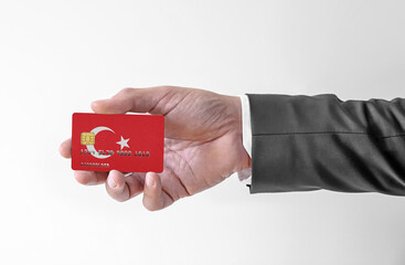 Bank credit plastic card with flag of Turkey holding man in elegant suit