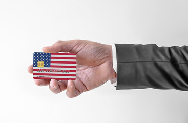 Bank credit plastic card with flag of United States holding man in elegant suit
