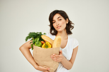 brunette in a white t-shirt packs food vegetables delivery