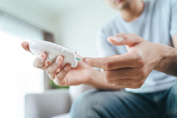 Asian man checking blood sugar level by Digital Glucose meter, Healthcare and Medical, diabetes,...