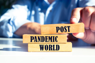 Wooden blocks with words Post-pandemic world. New normal social and business concept.