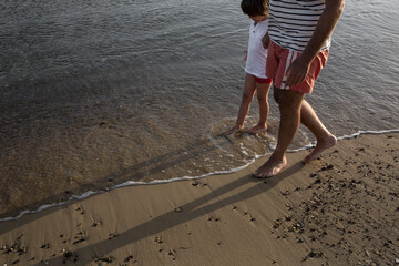 Father and son walking at the beach