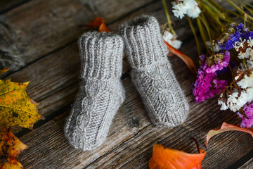 Fototapeta na wymiar Small handmade baby socks, made of organic sheep wool yarn