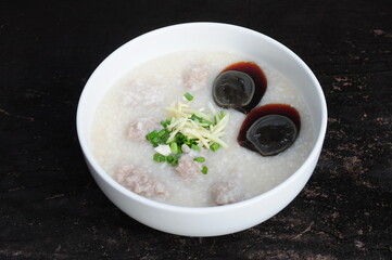 Congee with preserved egg in white bowl