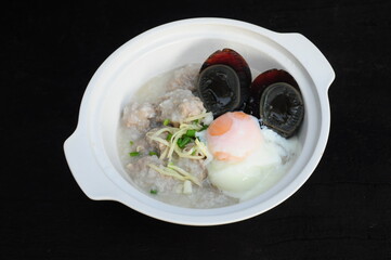 Congee with preserved egg in white bowl