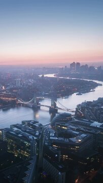 time lapse London skyline with illuminated Tower bridge and Canary Wharf in sunrise time, UK