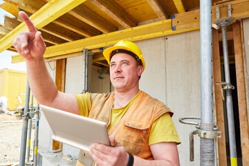 Foreman with tablet computer gives an instruction