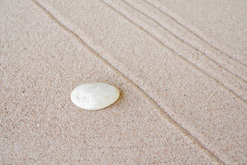 Zen garden stone Japanese on raked sand. rock or pebbles on beach design outdoor for meditate peace of mind and relax. Buddhism religion concept.