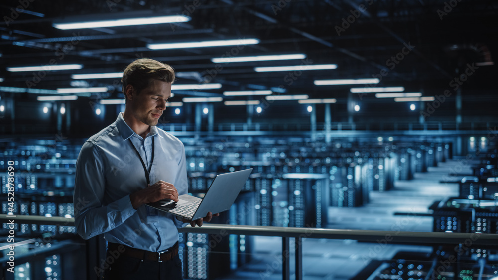 Poster Data Center Specialist Engineer Using Laptop Computer. Server Farm Cloud Computing Facility with Male Maintenance Administrator Working. Data Protection Network for Cyber Security.