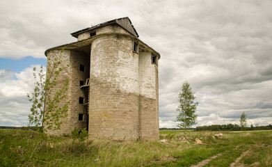 An old, abandoned brick building in the countryside.