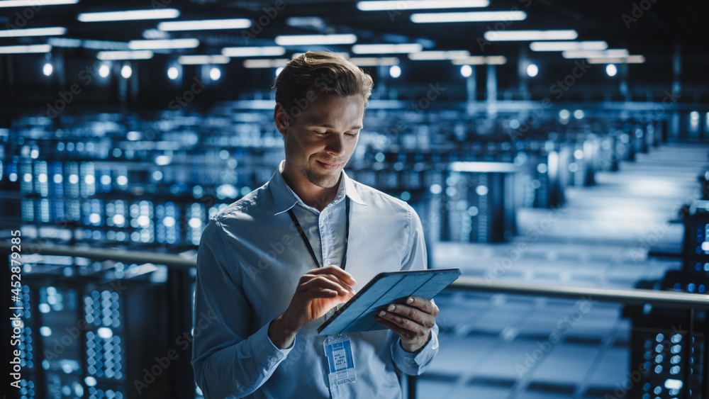 Fototapete Portrait of Smiling IT Specialist Using Tablet Computer in Data Center. Big Server Farm Cloud Computing Facility with Male Maintenance Administrator Working. Cyber Security, e-Business.