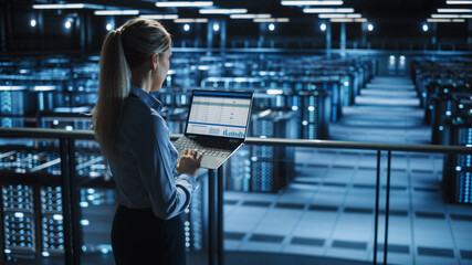 Data Center Female IT Specialist Uses Laptop Computer. Cloud Computing Server Farm with IT Engineer Monitoring Statistic, Maintenance Control. Information Technology of Fintech, e-Business. - obrazy, fototapety, plakaty