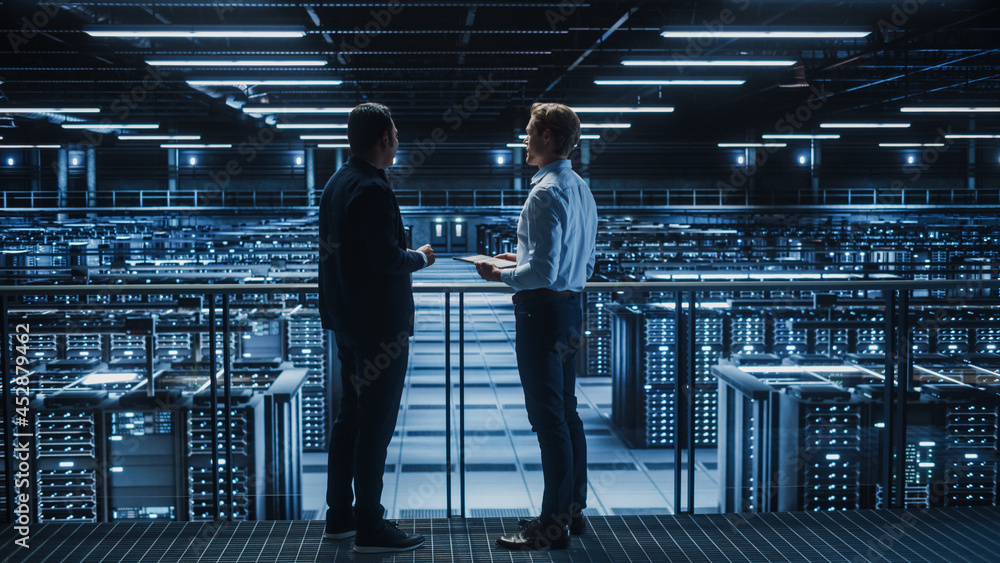 Aufkleber Data Center IT Specialist and e-Business Enrepreneur Talk, Use Laptop. Two Information Technology Professionals Walking on Bridge Overlooking Cloud Computing Server Farm.