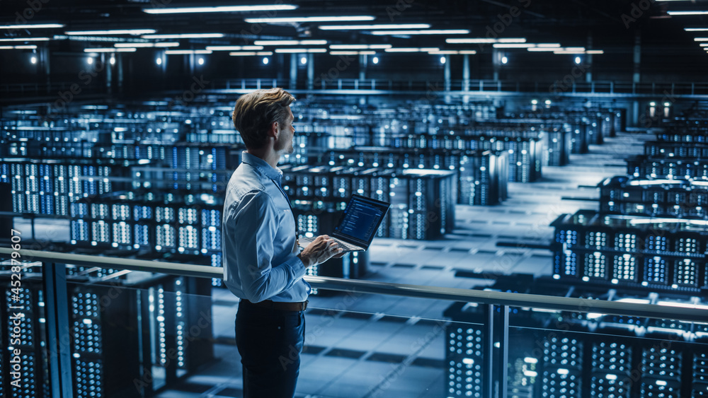 Aufkleber Handsome Smiling IT Specialist Using Tablet Computer in Data Center. Succesful Businessman and e-Business Entrepreneur Overlooking Big Server Farm for Cloud Computing.