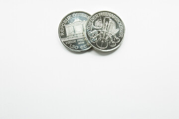 Big round silver coin covers other one on white background