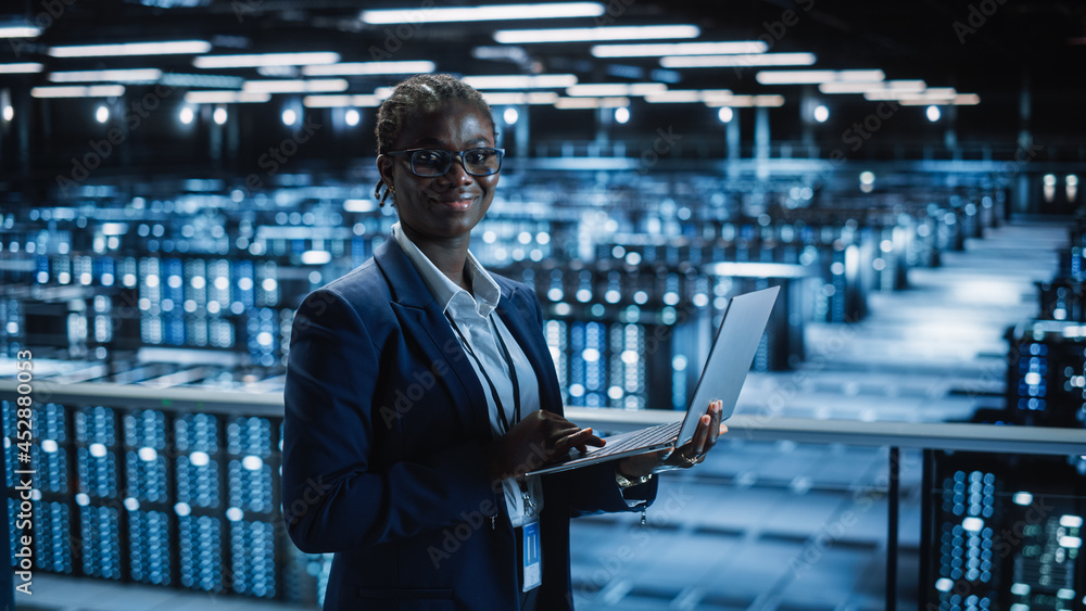 Poster Data Center: Female Programmer Using Laptop Computer, Smiling and Looking at Camera. In Cloud Computing Server Farm System Administrator Working on IT Maintenance for Iaas, saas, paas.