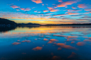 Fototapeta premium Sunrise waterscape with high cloud and reflections