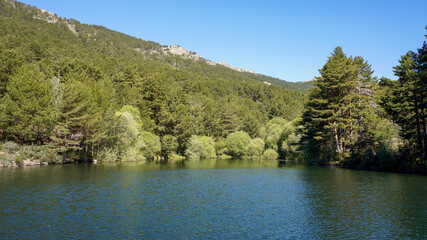Obraz premium lagoon and green mountainous forest background