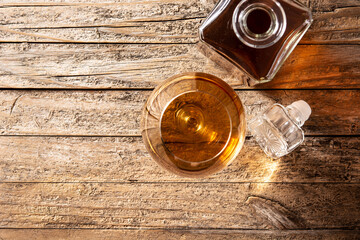 Cognac or whiskey drink on rustic wooden table. Top view. Copy space