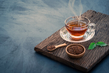Hot tea in a glass cup decorated with dried tea leaves